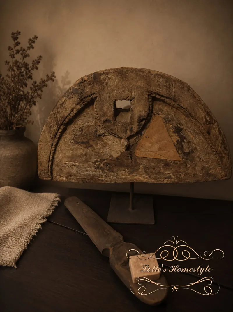 Oud houten wielornament op metalen standaard